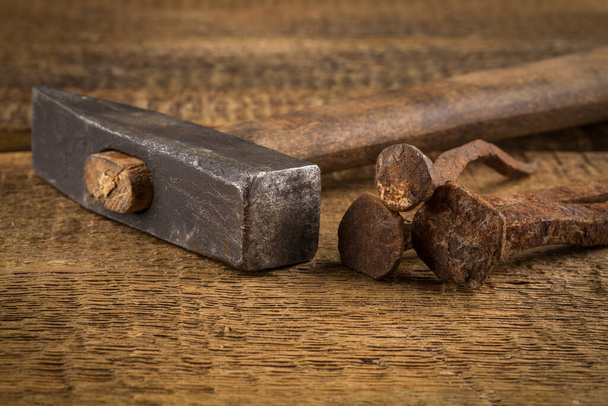 Vintage old hammer with rusty nails on wood table background - Foto, afbeelding