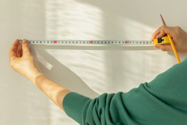 DIY interior hand motion, closeup, wallpaper length measurement - Valokuva, kuva