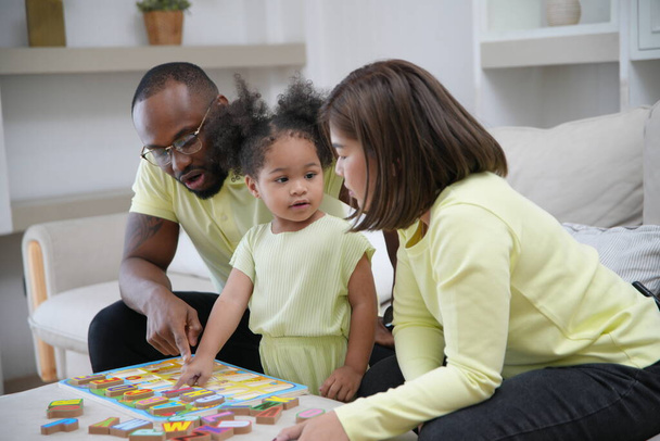 happy african american girl with parents learning letters  - Foto, Imagen