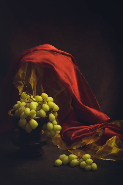 Stillleben mit Trauben, gelbem und rotem Stoff - Foto, Bild
