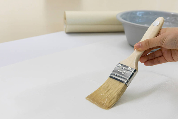 DIY interior hand motion, closeup, apply paste to wallpaper - Photo, image