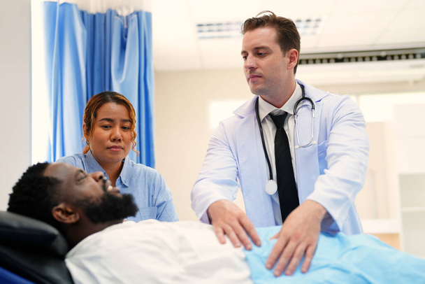 doctor examining african american patient in hospital - Foto, afbeelding