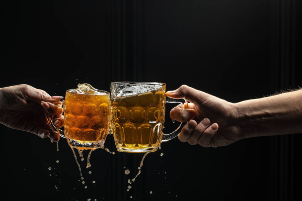 friends clinking beer glasses, Freeze motion splash drops of beer foam - Photo, Image