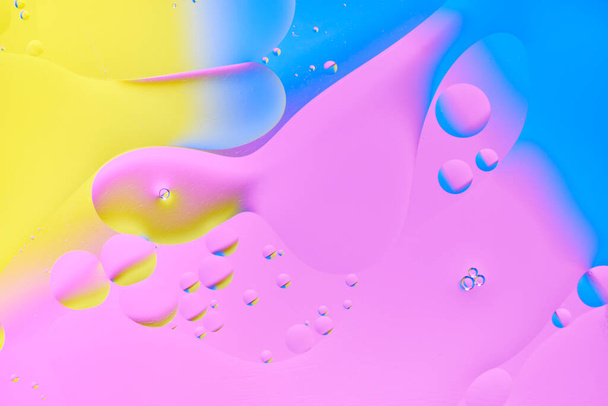 Bright abstract, multicolored background with oil circles.With blue, yellow and pink color - Foto, afbeelding