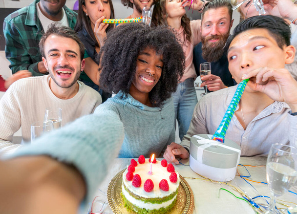 Joyful groep van multi-etnische vrienden nemen selfie tijdens het hebben van verjaardagsfeestje thuis, met behulp van mobiele telefoon en het drinken van champagne - Foto, afbeelding