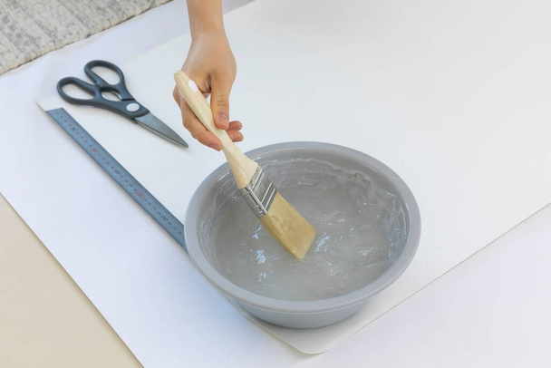 DIY interior hand motion, closeup, apply paste to wallpaper - Fotó, kép