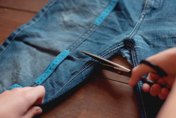 Denim Upcycling Ideas, Utilisation de vieux jeans, Repurposing Jeans, Réutilisation de vieux jeans, Upcycle Stuff. Femme couturière couper et réparer vieux jeans bleus. - Photo, image