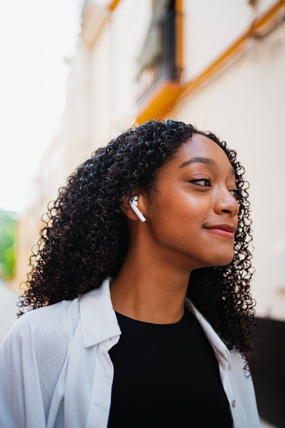 Close up tiro de mulher negra feliz ouvindo música em botões de ouvido sem fio - Foto, Imagem