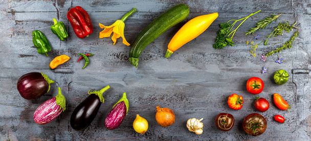 Melanzane, zucchine, pomodori, peperoni, aglio, cipolla e aromatici su sfondo grigio Vista dall'alto - Foto, immagini