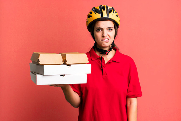 young pretty woman looking puzzled and confused. pizza delivery concept - Fotoğraf, Görsel