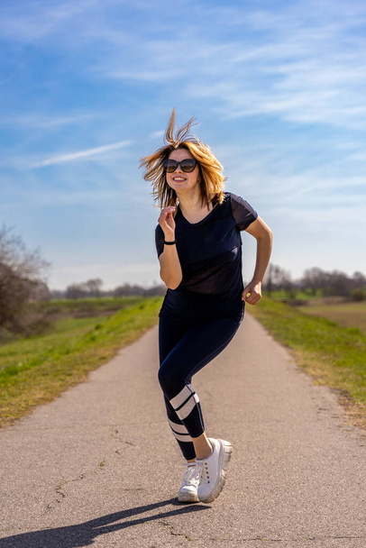 hermosa mujer deportiva divirtiéndose bailando en una carretera de campo - concepto de bienestar al aire libre - Foto, Imagen