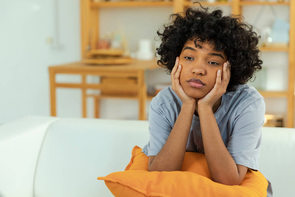 African american sad thoughtful girl at home. Young african woman feels depressed offended lonely upset suffers from abuse harassment heartbreak. Grieving violence victim has psychological problem - Фото, изображение