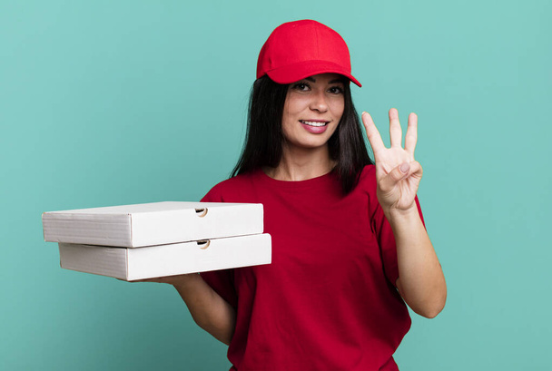 hispanic pretty woman smiling and looking friendly, showing number three. delivery pizza concept - Zdjęcie, obraz