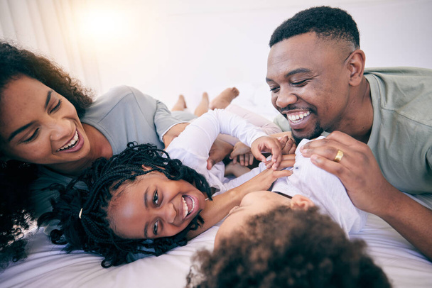 Laugh, tickle and morning with black family in bedroom for wake up, bonding and affectionate. Weekend, smile and care with parents and children at home for playful, funny and free time together. - Фото, изображение