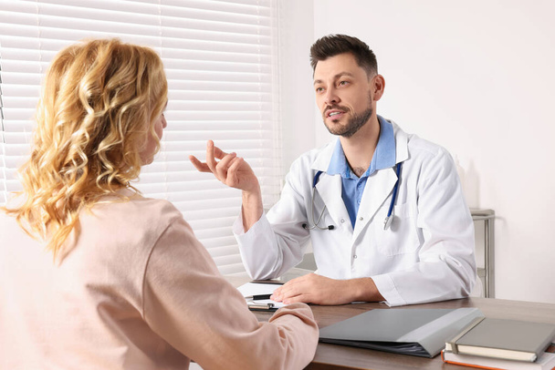 Doctor consulting patient at table in clinic - Photo, image