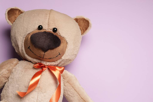 Cute teddy bear on light pink background, top view. Space for text - 写真・画像