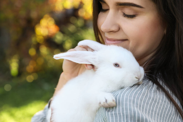 Happy woman with cute rabbit outdoors on sunny day, closeup. Space for text - Fotografie, Obrázek