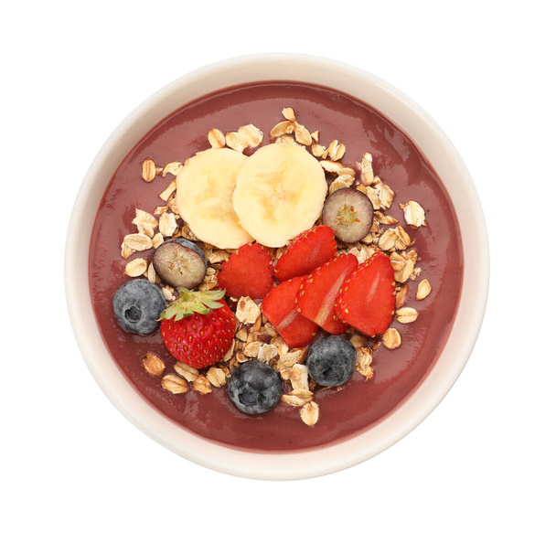 Delicious smoothie bowl with fresh berries, banana and granola on white background, top view - Foto, Imagen