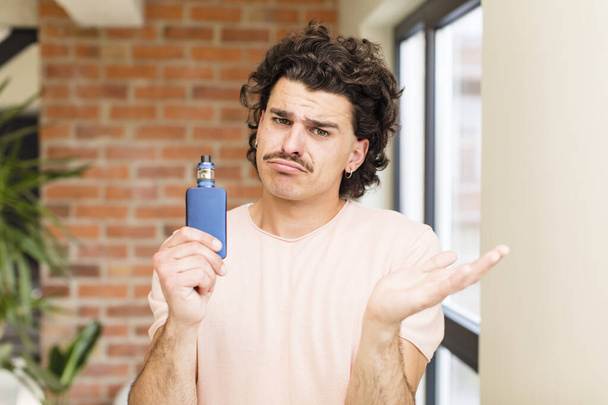 young handsome man with a vaper at home interior - Foto, immagini