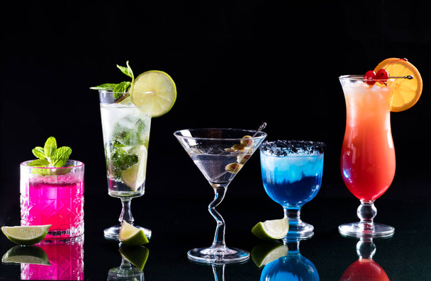 Bright glowing colourful cocktails in a row, against a black background.  - Φωτογραφία, εικόνα