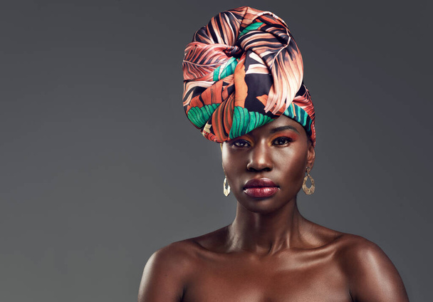 Kruunu ylös, aika kuningattarelle. Studio kuva kaunis nuori nainen yllään perinteinen Afrikkalainen pää kääri harmaata taustaa vasten - Valokuva, kuva