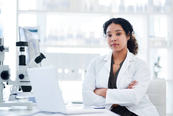 I play a big role in saving lives. Portrait of a female scientist sitting with her arms crossed at her desk - 写真・画像