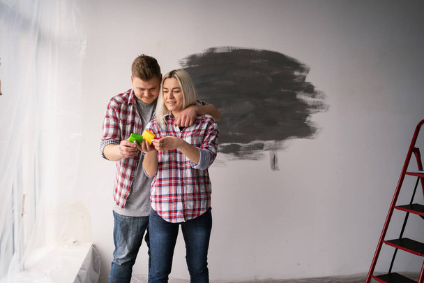 Usmívající se pár se dívá na barevné vzorky pro stěnu doma. Oprava, design interiéru, rekonstrukce a bytový koncept. Kopírovat prostor - Fotografie, Obrázek