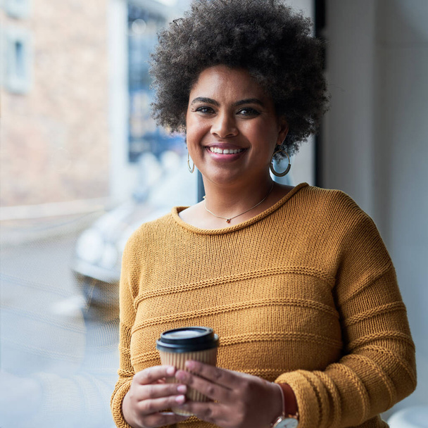 Success is a mentality. Portrait of an attractive young businesswoman drinking coffee and looking cheerful in her office at work - Fotoğraf, Görsel
