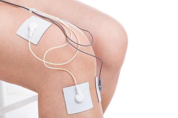 Electrostimulator massager treats knee trauma. Sports injuries. - Valokuva, kuva