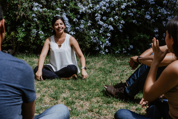 hispanic young people seated in circle on grass and participating at group therapy session in Mexico Latin America - Photo, image