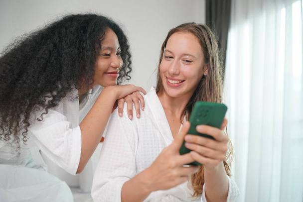 Technologie, Internet, Kommunikation und People-Konzept - glücklich lächelnde junge Frau, die im heimischen Schlafzimmer auf dem Smartphone SMS schreibt - Foto, Bild