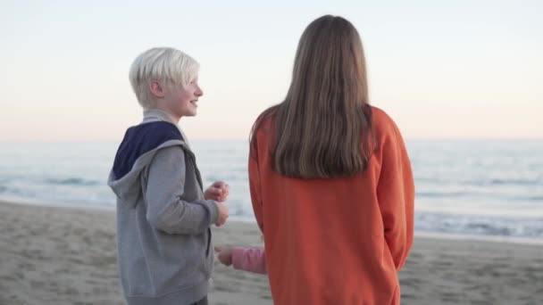 Підліток і дівчинка спокійно розмовляють на заході сонця біля моря (Туреччина, Аланья).. - Кадри, відео