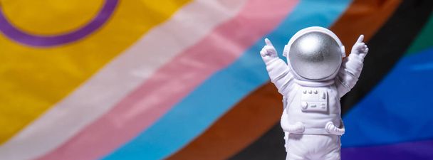 Gökkuşağı LGBTQIA bayrağında ipek malzeme arka planından yapılmış Banner Toy astronotu. Mutlu gurur ayları. LGBTQ gurur ayının sembolü. Eşit haklar. Barış ve özgürlük. LGBTQIA toplumunu destekleyin. Çeşitlilik - Fotoğraf, Görsel