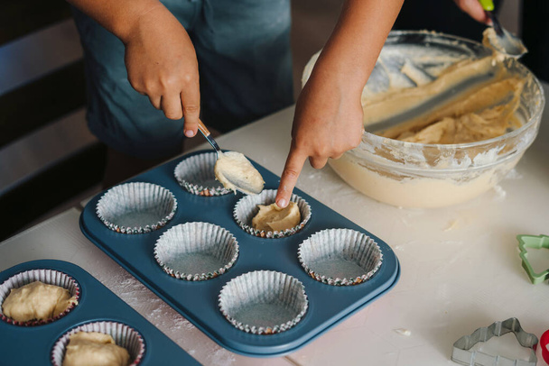 Kinderen handen hebben plezier koken muffin thuis samen, genieten van weekend spelen met kleine kinderen doen bakkerij koken in de keuken. Mensen lifestyle portret - Foto, afbeelding