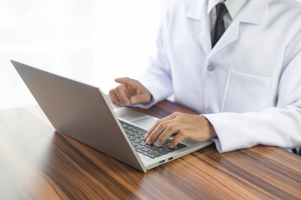 Doctor trabajando con computadora portátil en la oficina del hospital, concepto médico saludable - Foto, Imagen