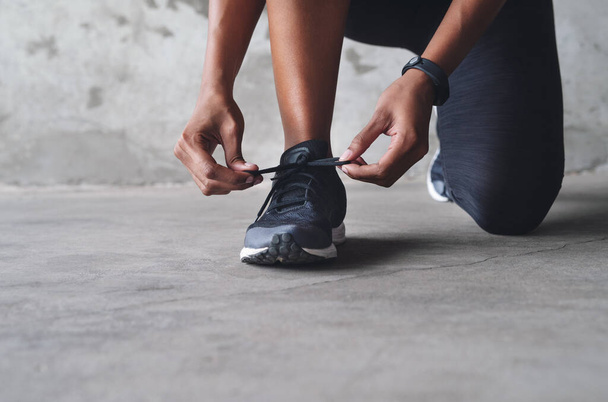 Очищений і готовий піти. невизначена спортсменка зав'язує свої шнурки під час тренувань у приміщенні
 - Фото, зображення