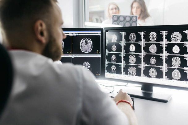 医学病院:神経科医はコンピュータを使用し,患者のMRIを分析し,脳を診断する. ヘルスクリニックラボ:専門医が機能するCTスキャンを検査 - 写真・画像