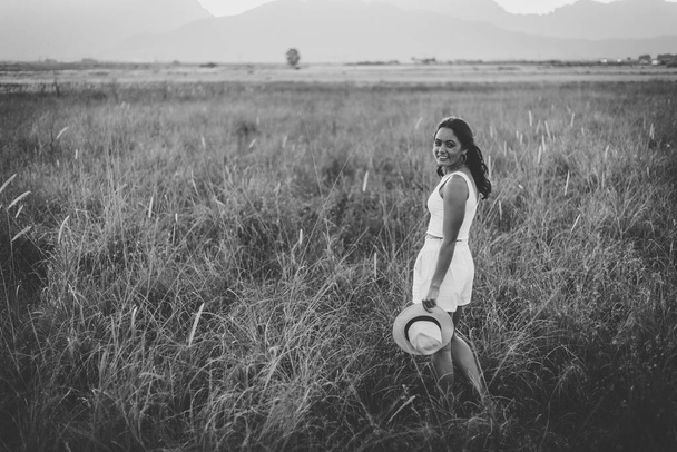 beautiful young woman with long dark hair in a field of tall grass.  - Photo, image