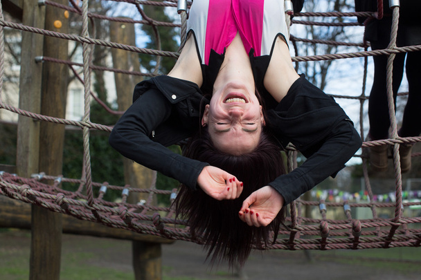 Adolescente chica colgando boca abajo en selva gimnasio
 - Foto, imagen