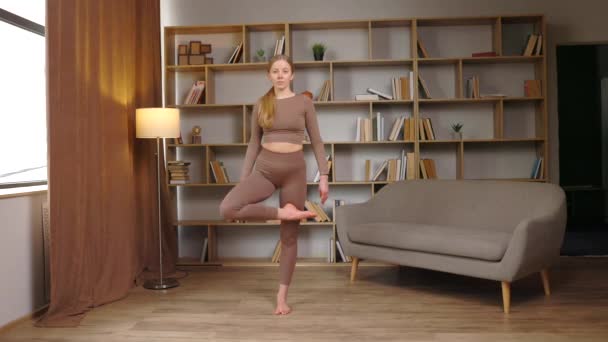 Die richtige Balance finden. Frau macht perfekte Baum-Pose im Zimmer neben dem Fenster, freier Raum - Filmmaterial, Video