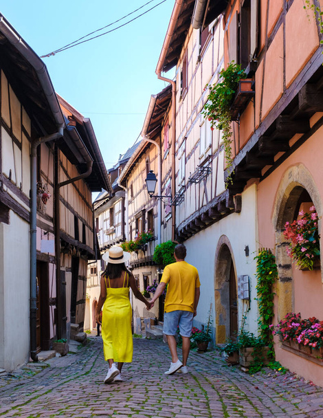 Para mężczyzn i kobiet na wakacjach w Eguisheim Francja Piękny widok na kolorowe romantyczne miasto Eguisheim w pobliżu Colmar latem - Zdjęcie, obraz