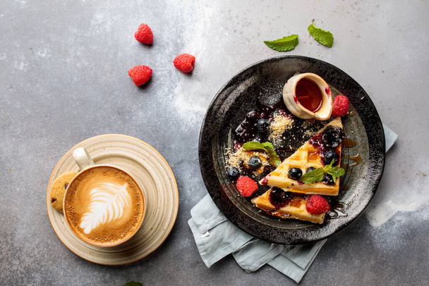 Очень ягодные вафли с черникой, малиной, клубникой, кофе эспрессо и печенье подаются в блюде изолированы на столе сверху вид на арабский завтрак - Фото, изображение