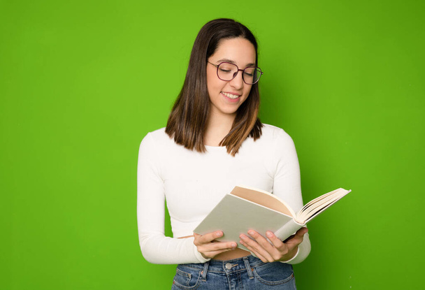 Φωτογραφία του χαμογελαστού λαμπερό toothy έξυπνη κυρία ανάγνωση βιβλίο φορούν casual στολή απομονωμένο πράσινο φόντο χρώμα - Φωτογραφία, εικόνα