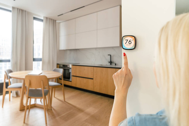 Thermostat Smart Home im Haus für die Temperatur. Winterheizung energieeffiziente Automation digitale Touchscreen-Wand Hand-Touch-Gerät, um die Heizung im Wohnzimmer anpassen. IoT-Domotik. - Foto, Bild
