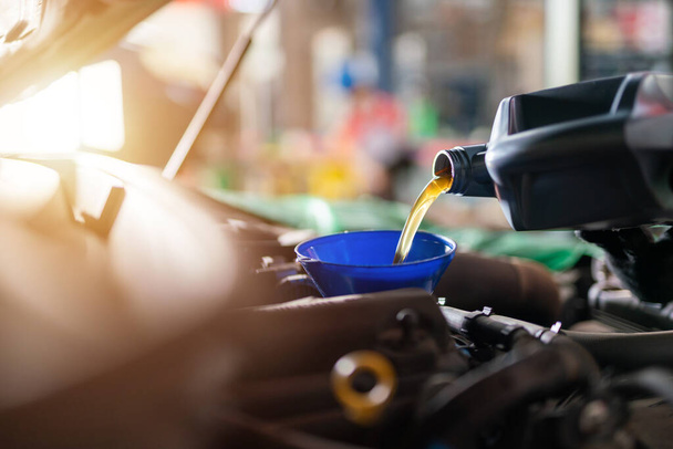 Auomobile repair, Refueling and pouring oil quality into the engine motor car Transmission and Maintenance Gear. Concept of quality engine oil. - Fotoğraf, Görsel