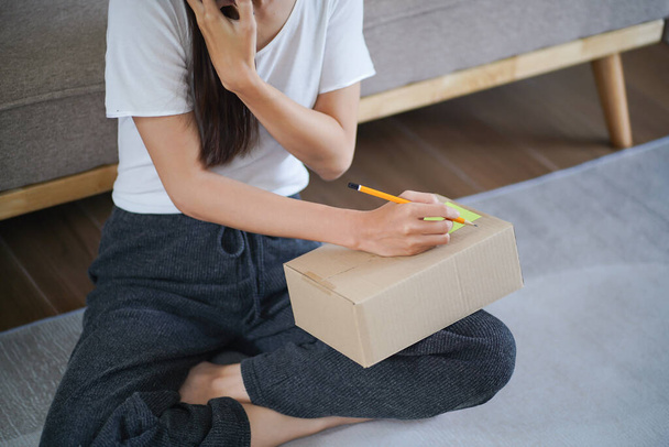 Business From Home Asian woman preparing package delivery box Shipping for shopping online. young start up small business owner at home online order. - Foto, Imagen