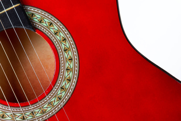 Yakın plan. Beyaz arkaplanda kırmızı akustik gitarın bir parçası - Fotoğraf, Görsel