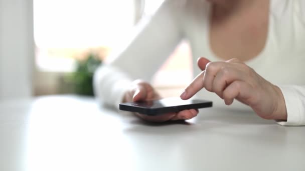 Молодая женщина, использующая приложения на мобильном сенсорном телефоне. Концепция использования технологий, покупок онлайн, мобильных приложений, текстовых сообщений, наркомании, свайп вверх, свайп вниз. Использование приложения для знакомств - Кадры, видео