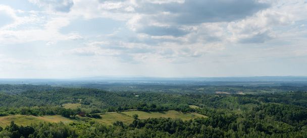 Hilly krajina panorama, vzdálené údolí plné mlhy, rozptýlené vesnice a svěží lesy - Fotografie, Obrázek