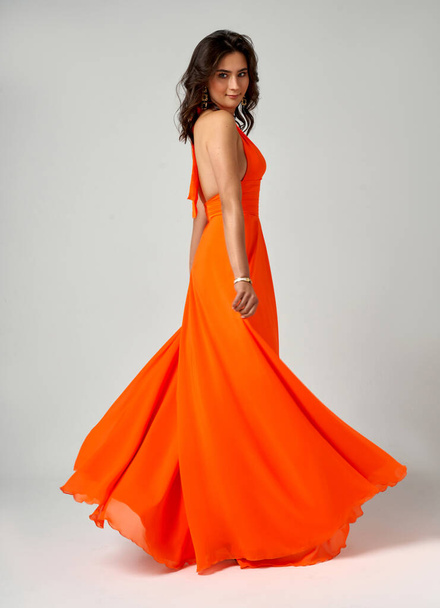 Sexy Fashion Model in Orange Dress over Gray Background - Фото, зображення